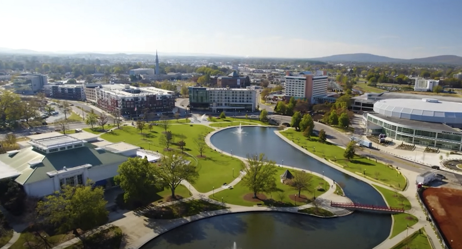 Overhead view of a city with green areas and lakes.