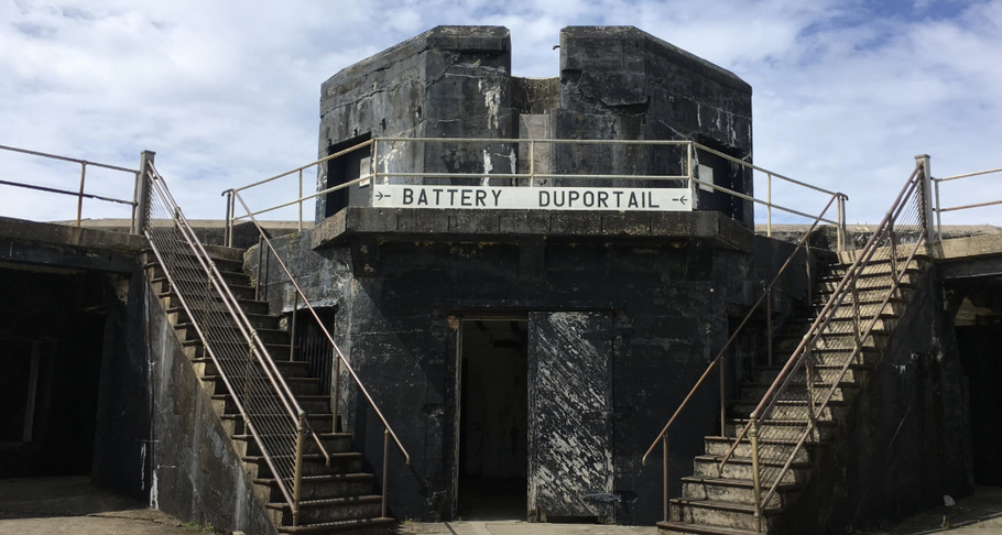 An old stone building with two staircases on each side and a sign in the middle that says 'Battery Dupportail.'