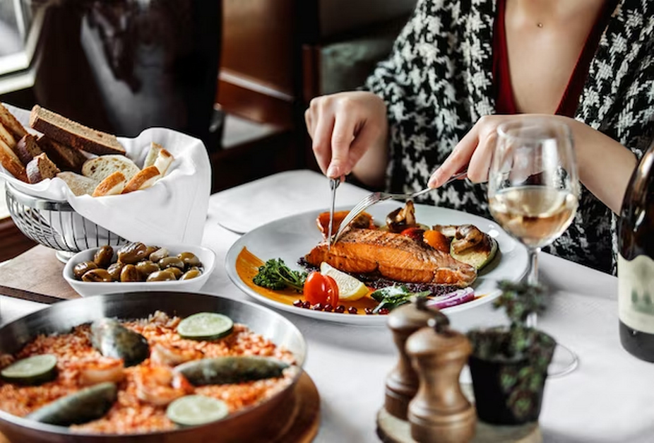 Woman with a plentiful seafood feast at a table.