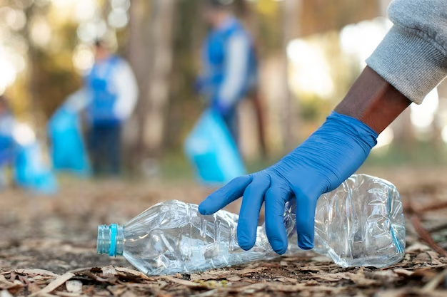 Hand with gloves holding a plastic bottle