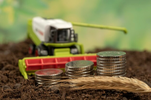 Toy truck, coins, and grain on soil